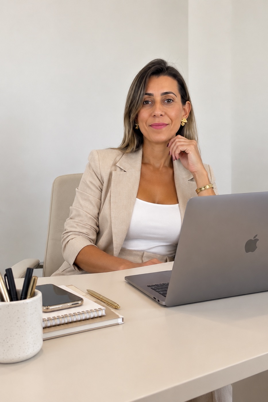 Ana Assis sentada à mesa de trabalho com notebook